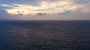 Aerial view of ocean sunset over the calm water surface.