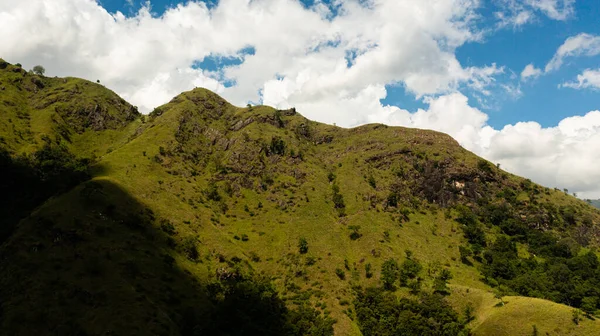 stock image Mountain slopes with green grass and forest against the blue sky and clouds. Mountain landscape in Sri Lanka.