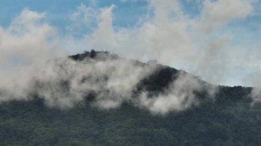 Aerial drone of the mountains with green forest through the clouds. Negros, Philippines