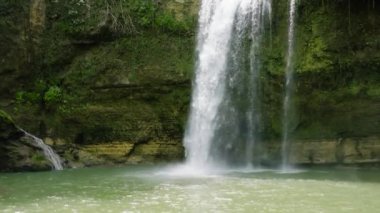 Beautiful waterfall in the rainforest. Slow motion. Ben-Ben Falls. Negros, Philippines.
