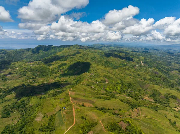 stock image Aerial view of farmland on a background of blue sky and clouds in a mountainous area. Negros, Philippines