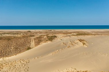 Tropik kumlu sahil ve mavi denizin havadan görünüşü. Paoay Kum Tepeleri, Ilocos Norte, Filipinler.