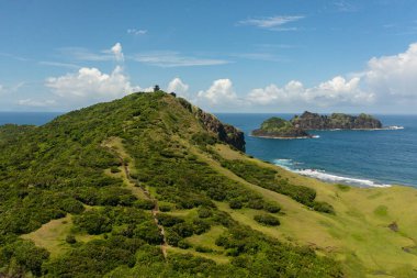 Mavi okyanusun arka planındaki deniz feneri ve tropikal adalar. Engano Burnu. Palaui Adası. Santa Ana Filipinleri.