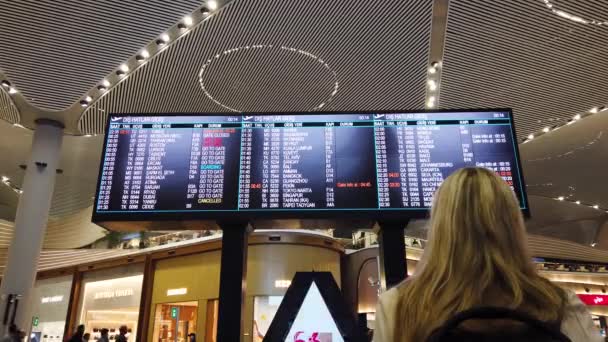 Kvinna Med Ryggsäck Internationell Flygplats Terminal Tittar Informationstavla Kontrollera Hennes — Stockvideo