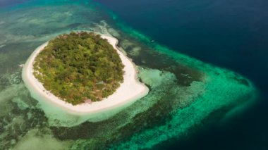 Mercan resifleriyle çevrili güzel kumlu plajlı bir mercan adasında küçük bir tropikal ada. Tropik ada ve mercan resifi. Yaz ve seyahat tatili konsepti, Camiguin, Filipinler, Mindanao
