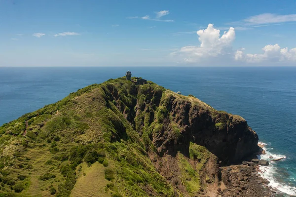 stock image Aerial drone of old lighthouse on a cape against the backdrop of the ocean and blue sky. Cape Engano. Palaui Island. Santa Ana Philippines.