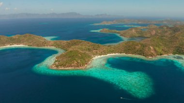 Mavi lagünü, mercan kayalıkları ve kumlu plajı olan tropikal adalar. Palawan, Filipinler. Turkuaz lagünlü Malezya adaları..
