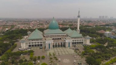 Camili Surabaya şehri, Al Akbar, karayolu, gökdelenler, binalar ve evler. Endonezya 'nın Surabaya kentindeki Al Akbar camii. Java Endonezya adasında minareleri olan güzel bir cami.