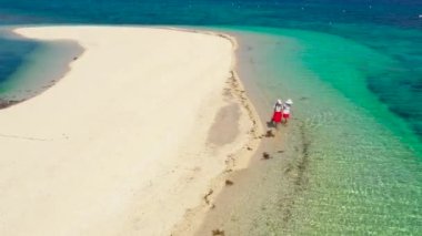 İki kız plaj boyunca yürüyorlar. Tropikal bir adada beyaz kumsal. Himokilan Adası, Leyte Adası. Turkuaz gölü olan beyaz kumlu plaj. Yaz tatili konsepti.