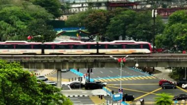 Kuala Lumpur, Malezya - 11 Eylül 2022: Trenle tek tren ve Kuala Lumpur 'da arabalarla kavşak. Şehirdeki trafik kavşağı.