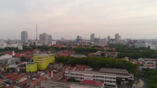 空中都市現代都市高層ビル 建物や家を持つスラバヤ 高層ビルやビジネスセンターが立ち並ぶ街のスカイラインの夕日スラバヤ首都圏東ジャワ インドネシア — ストック動画