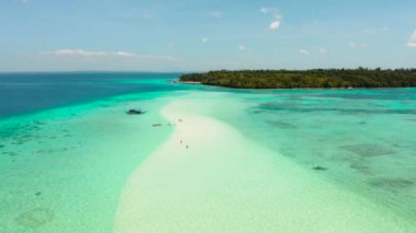 Turkuaz suları ve mercan resifleri arasında turistlerin olduğu kumsal. Mansalangan kum yığını. İskeledeki sahil. Yaz ve seyahat tatili konsepti. Balabac, Palawan, Filipinler.