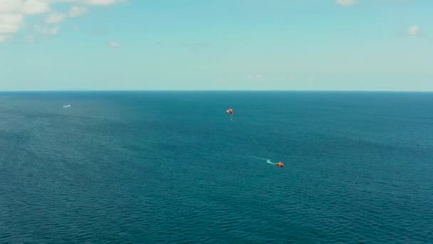 Renkli Bir Paraşütle Uçan Insanlar Bir Motorlu Tekne Tarafından Çekiliyor — Stok video