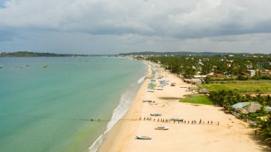 Sri Lanka - August 25, 2021: Aerial view of group of fishermen pulling nets from the sea. Trincomalee.