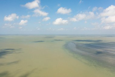 Dalgalı mavi okyanus ve bulutlu gökyüzü, deniz manzaralı. Gökyüzünde dalgalar olan mavi deniz suyu. Yaz ve seyahat tatil konsepti.
