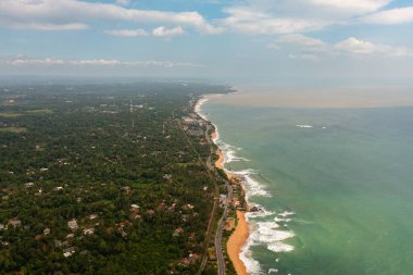 Güzel sahil, yukarıdan turkuaz su manzaralı palmiye ağaçları. Hikkaduwa, Sri Lanka.