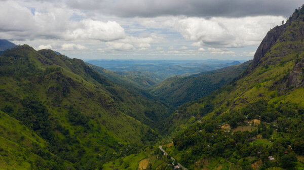Fresh green foliage, tropical plants and trees covers mountains and ravine. Ella Rock, Sri Lanka.