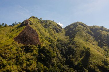 Tropikal bitki örtüsü ve ağaçlarla dolu bir dağın hava aracı mavi gökyüzü ve bulutların arka planına karşı. Sri Lanka 'daki dağ manzarası.