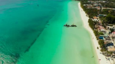 Boracay 'ın Beyaz Sahili ve insanlar Grotto Willys Kayası' nın yakınındaki turkuaz maviş denizinde yüzerler ve üzerinde Bakire Meryem Heykeli bulunur. Uzayı metin için kopyala. Yaz ve seyahat tatil konsepti.