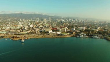 Cebu City, a major city on the island of Cebu, with skyscrapers and seaport with ships and ferries in the early morning. Philippines.