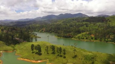 Hills with tea plantations around the lake in the mountains. Maskeliya, Castlereigh, Sri Lanka.