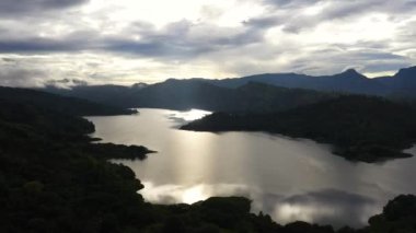Sabahın erken saatlerinde yeşil tepeler ve dağların arasında gölün insansız hava aracı. Tropik bir manzara. Victoria Barajı, Sri Lanka.