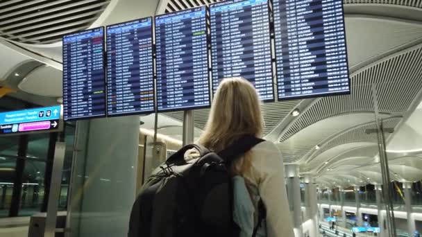 Kobieta Plecakiem Międzynarodowym Terminalu Lotniskowym Patrząca Tablicę Informacyjną Sprawdzająca Lot — Wideo stockowe
