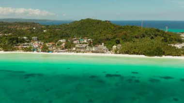 Seyahat konsepti: Mavi göl kenarında otelleri ve turistleri olan kumlu tropikal plaj, hava manzarası, Boracay, Filipinler. Tropikal adada sahili olan deniz burnu. Yaz ve seyahat tatil konsepti.