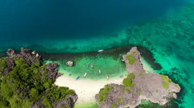 Tropikal manzara: Lahos Adası güzel plajlar ve turkuaz su manzaralı turistler. Caramoan Adaları, Filipinler. Yaz ve seyahat tatil konsepti.