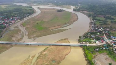 Manzara, nehir ve kasaba üzerindeki köprü, üst manzara. Yaz ve seyahat tatili konsepti. Luzon Adası, Filipinler 'in doğası. Arabalar köprüde ilerliyor..