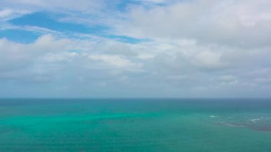 Dalgalı mavi okyanus ve bulutlu gökyüzü, deniz manzaralı. Su bulutu arkaplanı. Gökyüzüne karşı dalgalı mavi deniz suyu.
