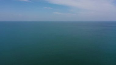 Dalgalı mavi denizin ve bulutlu gökyüzünün havadan görünüşü. Okyanus silüeti.