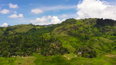 Mavi gökyüzü ve bulutlarla kaplı yeşil tepeler ve dağlar. Sri Lanka.