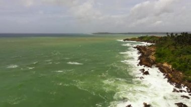 Palmiye ağaçları ve okyanus sörfü olan kıyı şeridi. Seyahat konsepti. Gizli Sahil Mirissa, Sri Lanka.