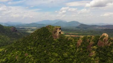 Yeşil ormanlarla kaplı dağların ve ormanın mavi gökyüzüne ve bulutlara dayandığı vadilerin hava aracı. Sri Lanka.