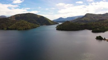 Dağların arasında mavi gökyüzüne ve bulutlara karşı bir göl. Randenigala rezervuarı, Sri Lanka.