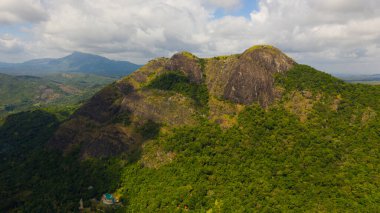 Mountains covered rainforest, trees and blue sky with clouds. Sri Lanka.