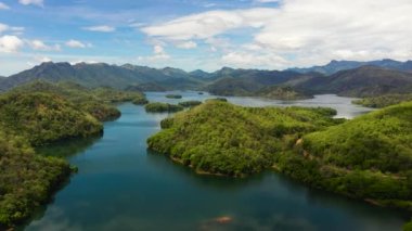 Mountain lake among hills with tropical vegetation and blue sky with clouds. Randenigala reservoir, Sri Lanka.