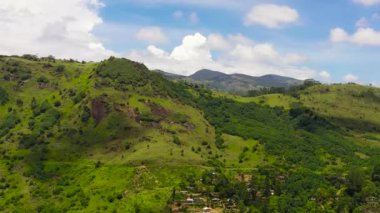 Yeşil tepelerin ve dağların üst manzarası mavi gökyüzü ve bulutların arka planına karşı. Sri Lanka.