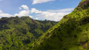 Gökyüzünden yeşil bitki örtüsü ve ağaçlarla kaplı dağların ve tepelerin havadan görünüşü. Sri Lanka 'daki dağ manzarası.