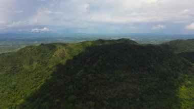 Aerial view of Mountains covered rainforest, trees and blue sky with clouds. Sri Lanka.
