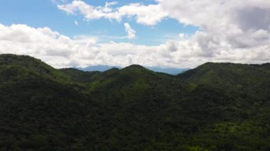 Aerial view of Mountains covered rainforest, trees and blue sky with clouds. Sri Lanka.
