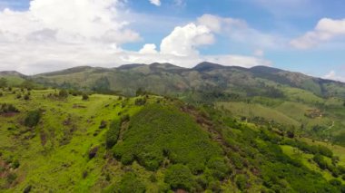 Dağlık bir alanda yeşil tepelerin manzarası mavi gökyüzü ve bulutların arka planına karşı. Sri Lanka.