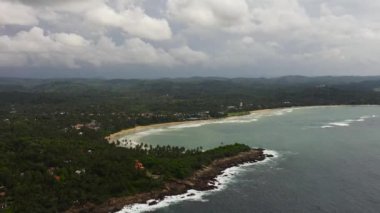 Top view of coast with a beach and hotels among palm trees. Dickwella Beach, Sri Lanka.