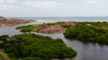 Tropikal bitki örtüsü olan göl manzarası ve sahili olan kıyı şeridi. Arugam Körfezi, Sri Lanka.