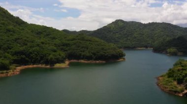 A beautiful lake among the mountains with a green forest. Victoria Reservoir, Sri Lanka.