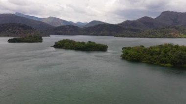 Dağların arasında ormanla kaplı bir göl. Sri Lanka, Victoria Randenigala Rantembe Sığınağı.