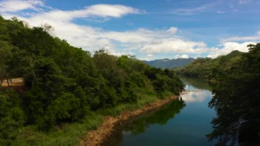 Dağların ve tepelerin arasında, gökyüzüne ve bulutlara karşı ormanı olan bir nehir. Randenigala rezervuarı, Sri Lanka.