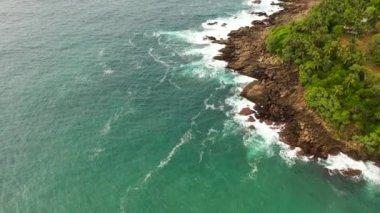 Dalgalar kayalık sahilde kırılır. Sri Lanka adasının kıyısında.