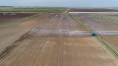 Merkez pivot fıskiye sistemini kullanarak Ekin Sulama 'nın havadan görüntüsü. Tarım arazilerini sulayan bir sulama rotası. Sulama sistemi tarım arazilerini suluyor.